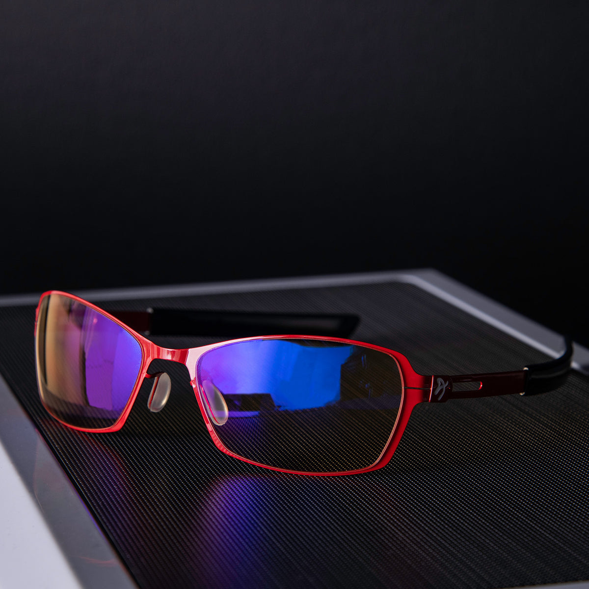 Arozzi Visione VX-500 blue light glasses rest on a black textured surface.