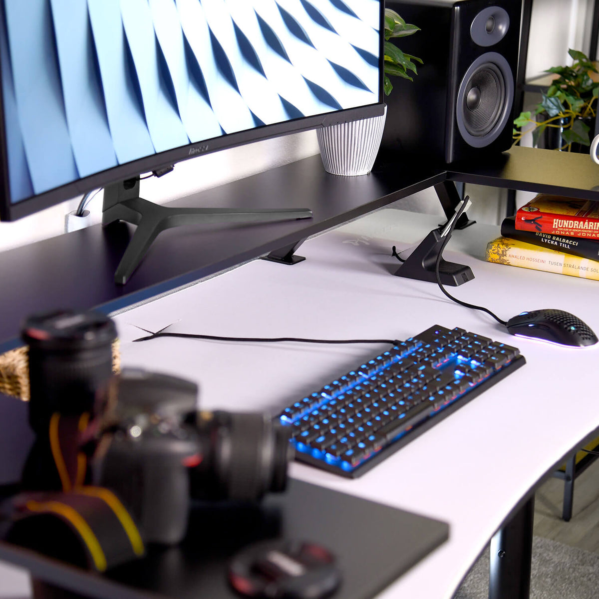 Arozzi Europe Desk Riser - Small with a curved monitor, keyboard, mouse, camera, and speakers.