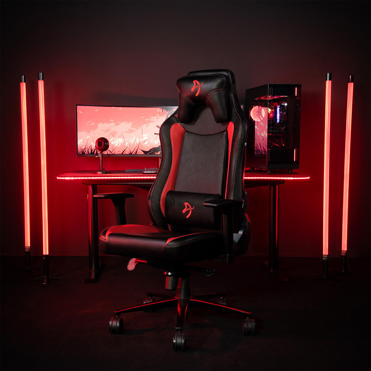 Arozzi Europe Vernazza SoftPU ergonomic chair in front of desk with red lights glowing behind.